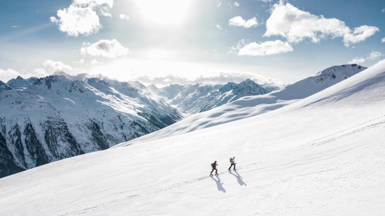 montagne avec deux alpinistes qui gravissent le sommeet